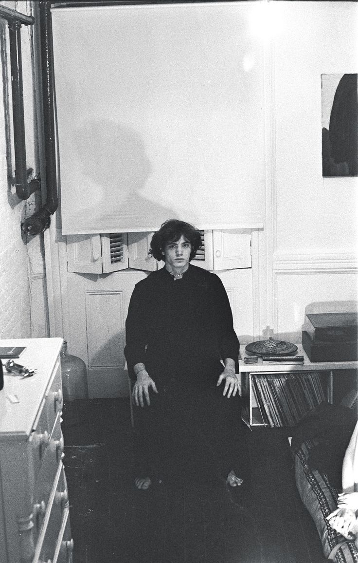 black and white photograph of a woman sitting on the floor in a room full of records