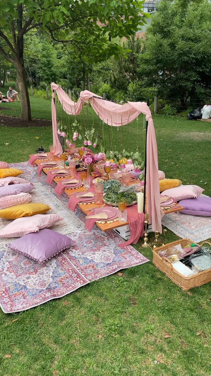 an outdoor picnic is set up in the grass with pillows and other items on it