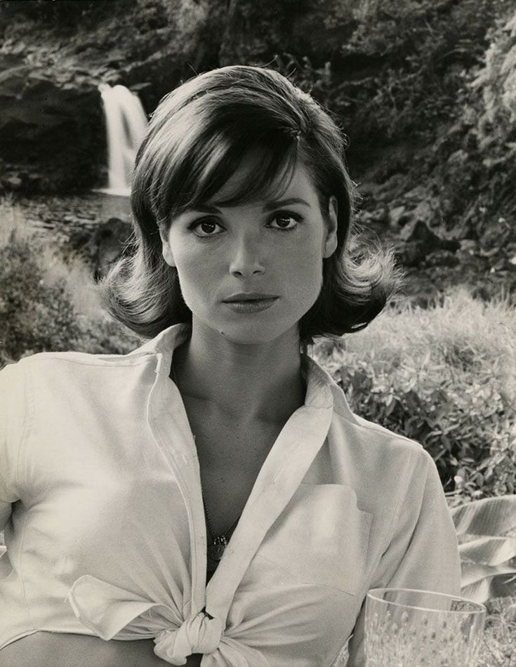 black and white photograph of a woman in front of a waterfall