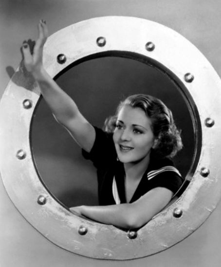 an old photo of a woman in a sailor's uniform looking through a porthole