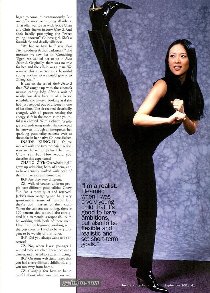 a woman in black is posing with her leg up and one hand on her hip