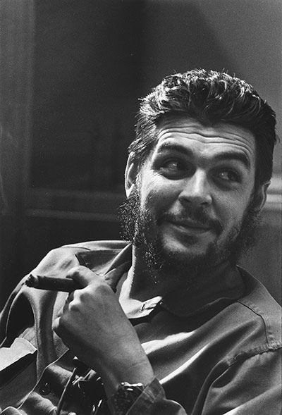 a black and white photo of a man with a goatee on his head smiling