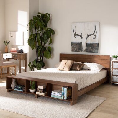 a bed sitting in a bedroom next to a table with drawers on top of it