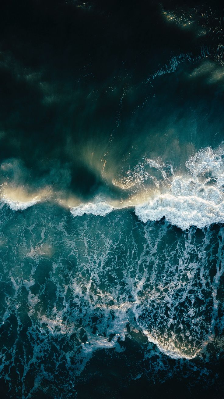 an aerial view of the ocean with waves