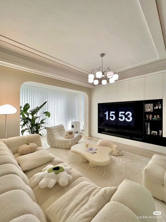a living room filled with furniture and a large flat screen tv mounted on the wall