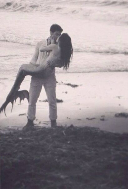 a man carrying a woman on his back at the beach