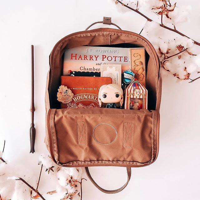 a harry potter book bag sitting on top of a table next to some branches with flowers