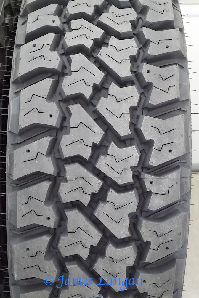 an image of a truck tire that is very close to the ground and has tread marks on it