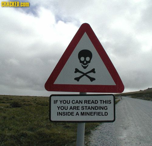 a road sign with a skull and crossbone on it in the middle of nowhere