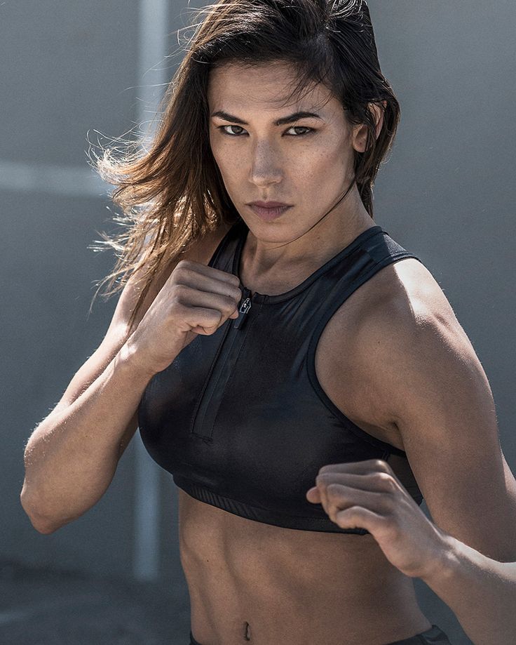 a woman in black sports bra top posing for the camera