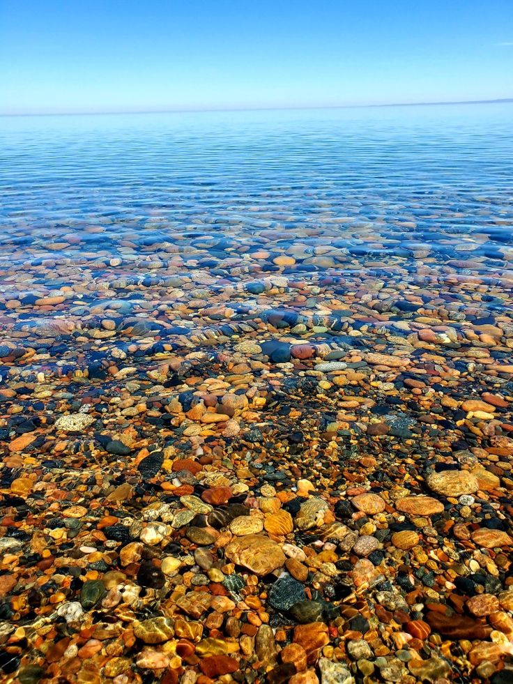 the water is very clear and blue with rocks in it's bottom half, as well