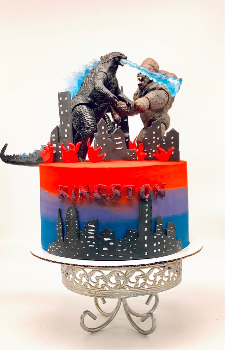 there is a cake that has godzillas on the top and an elephant on the bottom