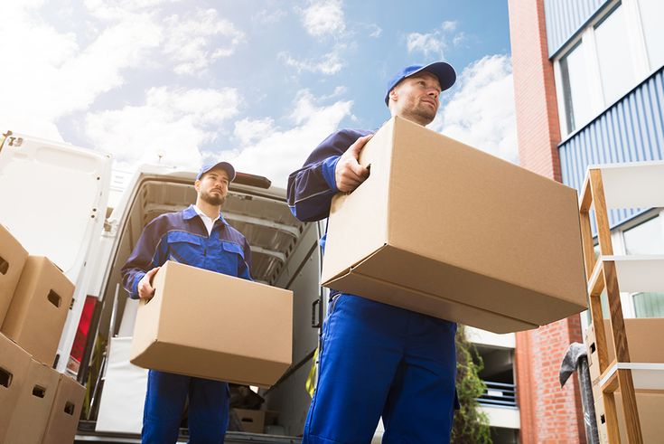 two men carrying boxes in front of a moving truck with the words relocato removals on it