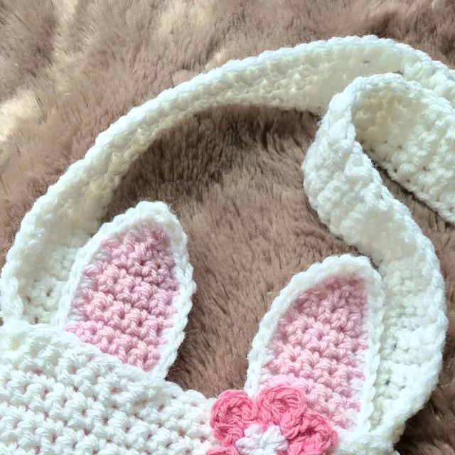 a crocheted bunny hat with pink and white ears