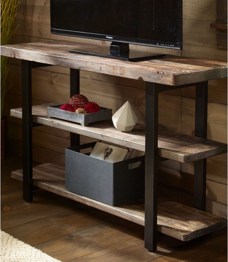 a flat screen tv sitting on top of a wooden shelf