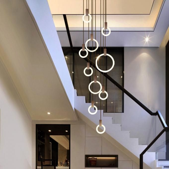 an elegant staircase with chandelier and modern lighting