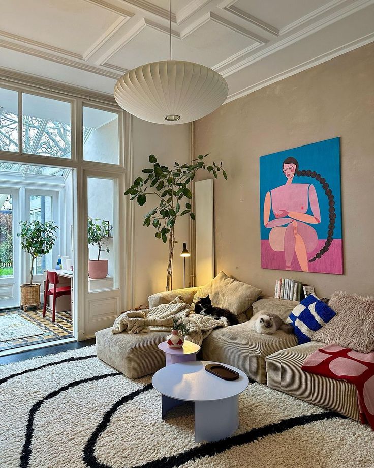 a living room filled with furniture and a large painting hanging on the wall above it