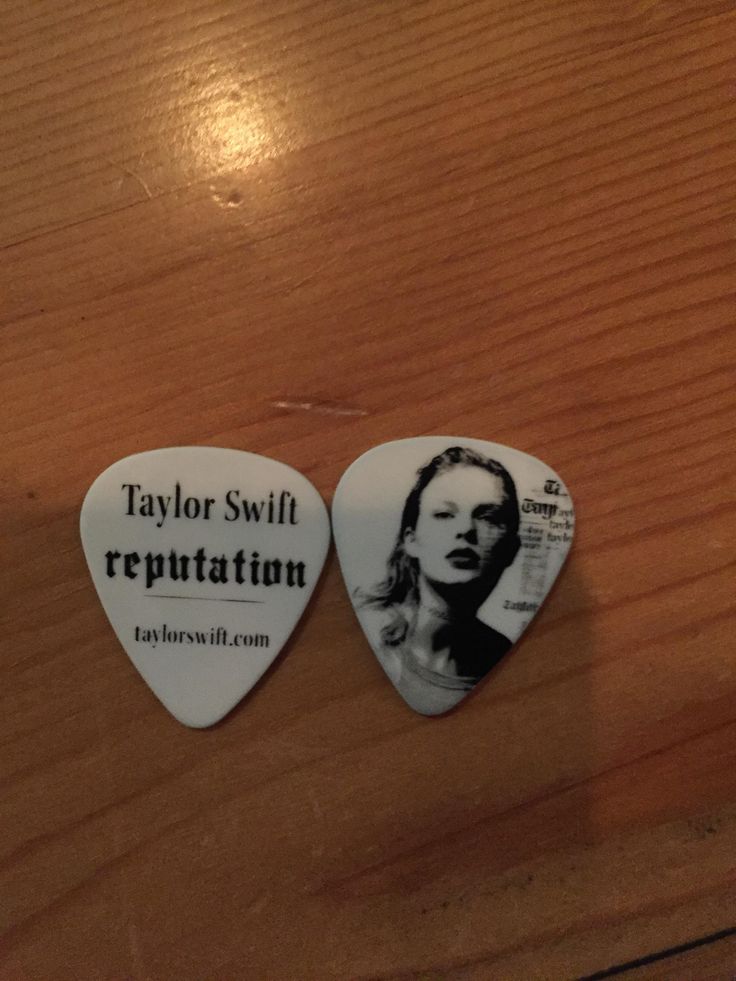 two guitar picks with taylor swift's repentation on them sitting on a table