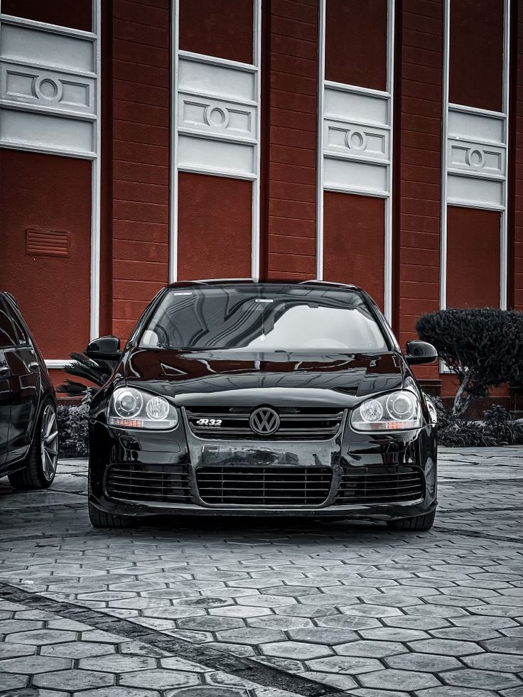 two cars parked next to each other in front of a building