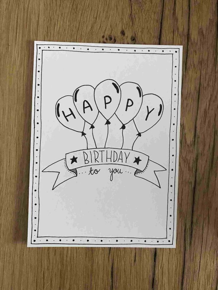 a happy birthday card with balloons and ribbon on the front, sitting on a wooden surface