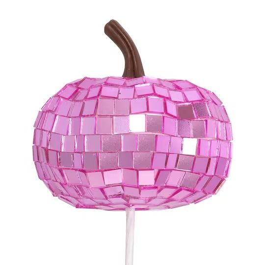 a pink mosaic apple sitting on top of a white stick