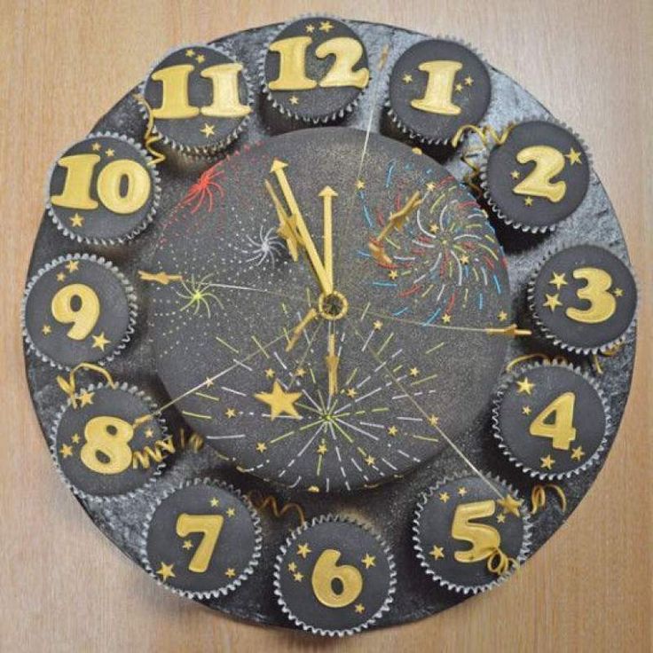 a clock made out of cupcakes with numbers and fireworks on the front side