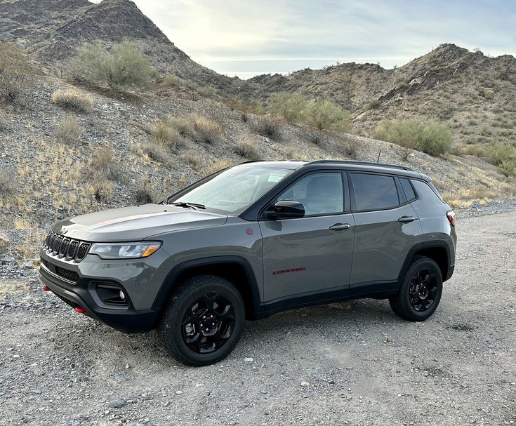 a grey jeep is parked in the desert