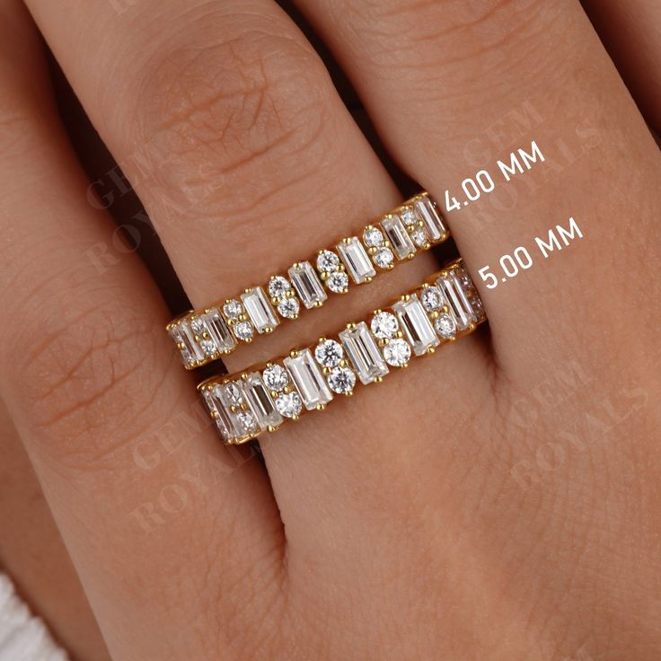 a woman's hand with two gold rings on top of her finger and the middle one has three baguettes in it