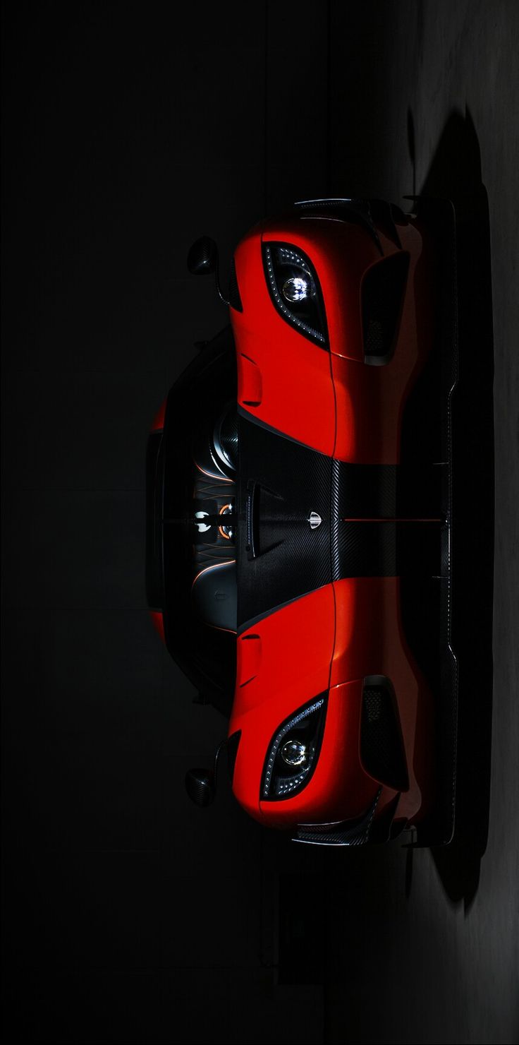 an overhead view of a red sports car in the dark