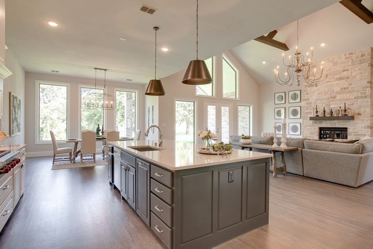 a large open concept kitchen and living room in a house with wood floors, white walls and windows