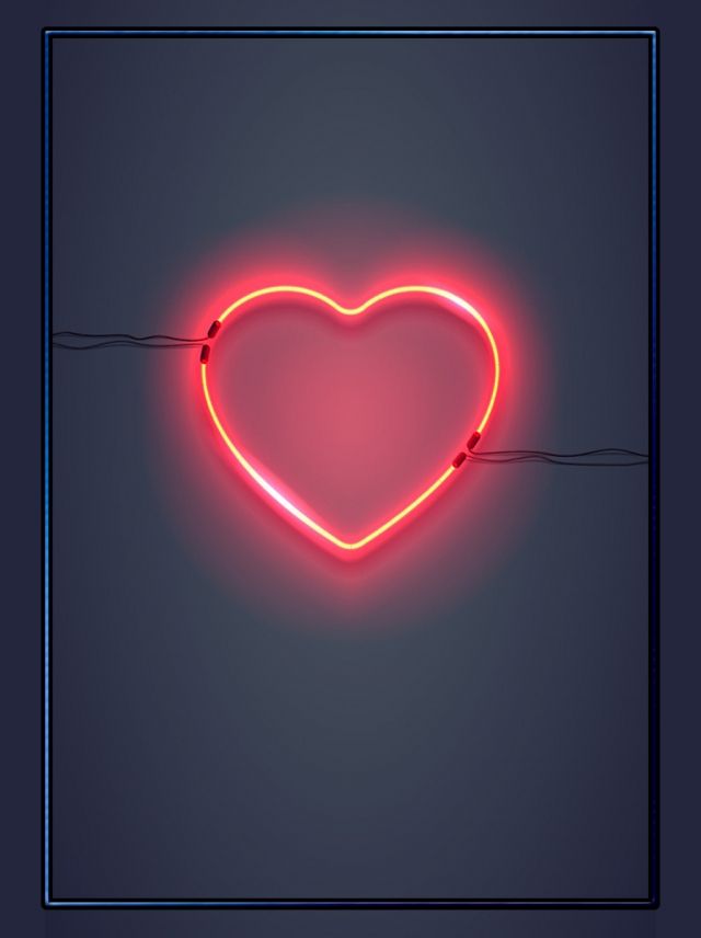 a heart shaped neon sign hanging from a wire