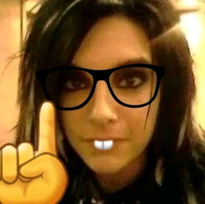 a woman wearing glasses making the peace sign with her fingers