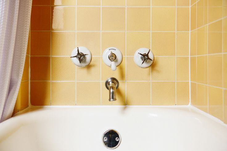 a bathroom sink with three faucets on the wall