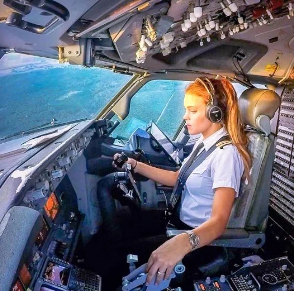 a female pilot in the cockpit of an airplane