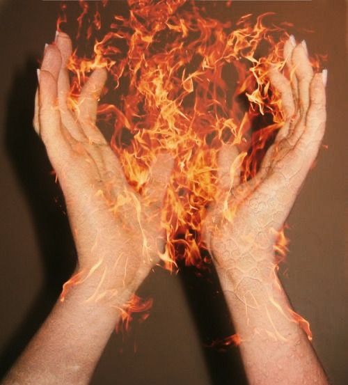 two hands are shown with fire in the middle and on top of them, both holding their hands together