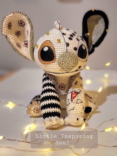 a small stuffed animal sitting on top of a white table covered in lights and string