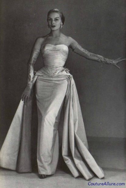 an old black and white photo of a woman in a dress with her arms outstretched