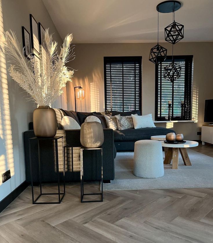 a living room filled with lots of furniture next to a window covered in shades of white