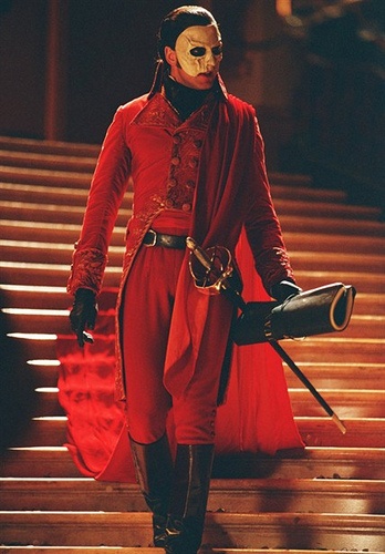 a man dressed in red and wearing a mask