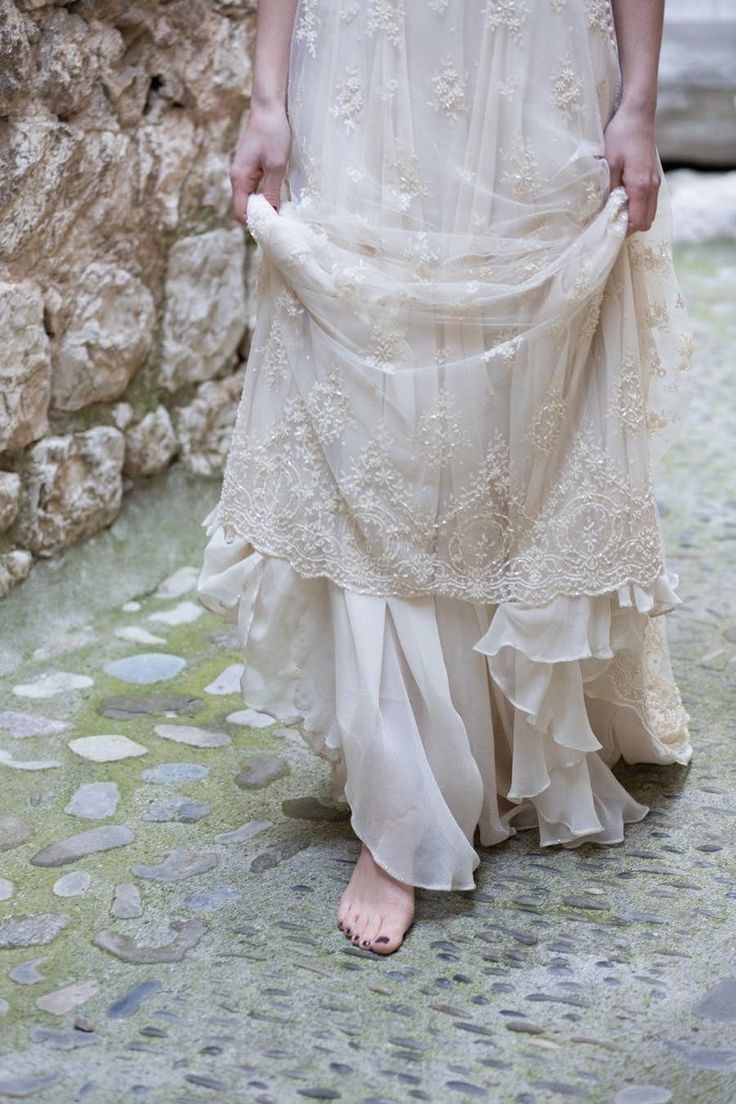 a woman in a white dress is walking down the street