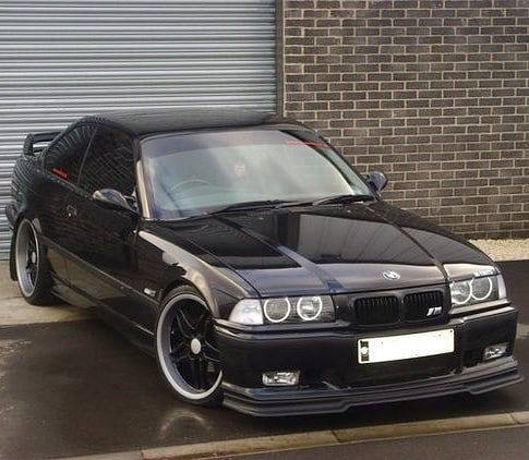 a black car parked in front of a garage