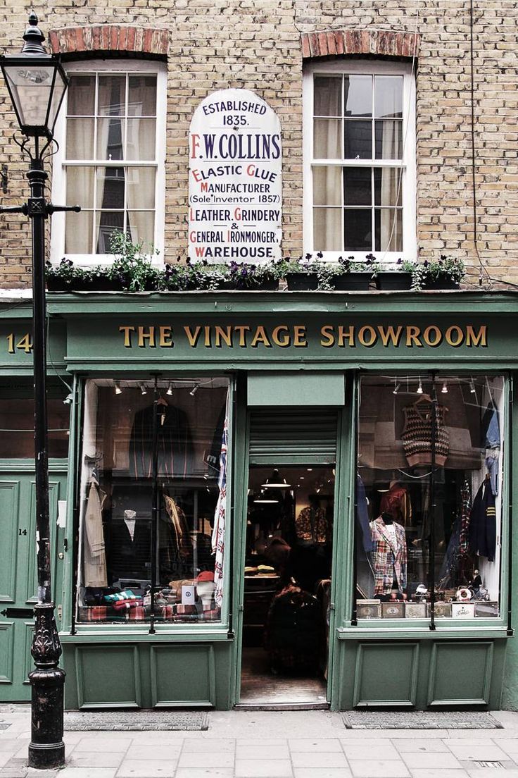 the vintage showroom is located in front of a brick building with green shutters