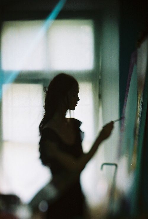 black and white photograph of woman writing on wall