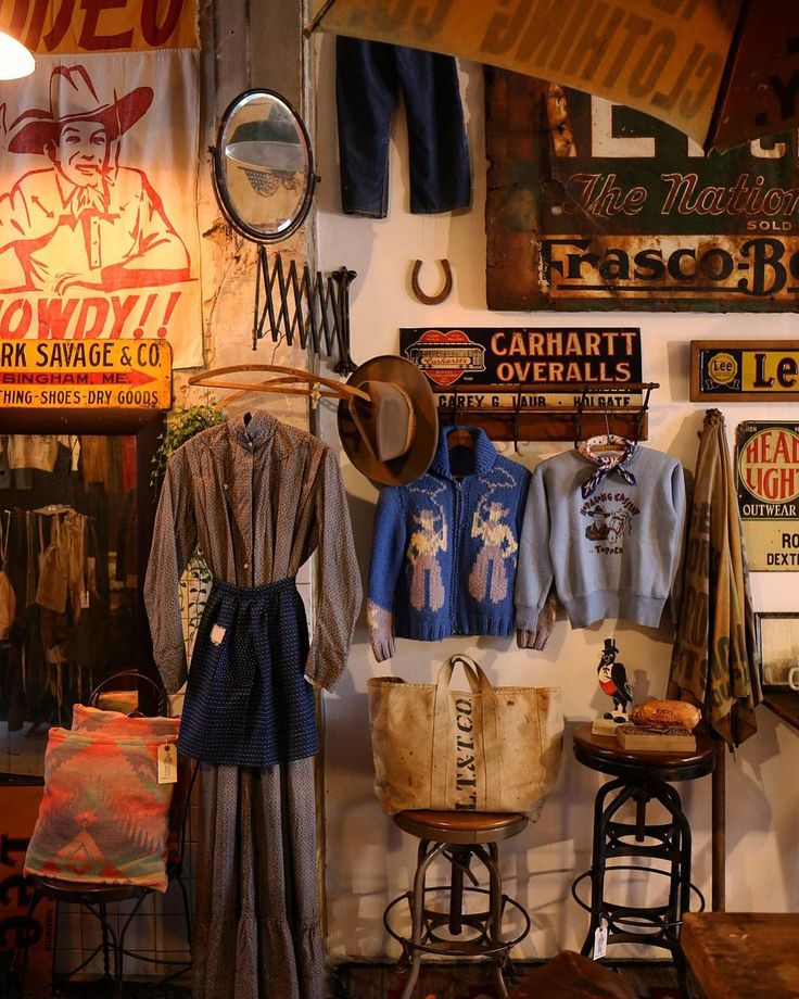 an old fashion clothing store with vintage signs on the wall and clothes hanging from hooks