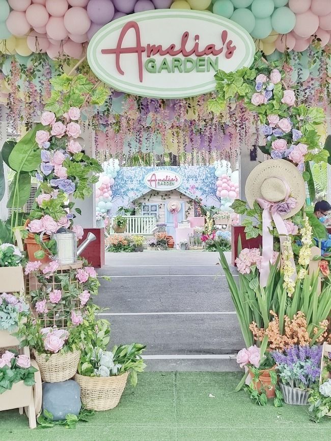 the entrance to amelie's garden is decorated with flowers, balloons and greenery