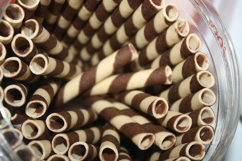 several brown and white striped straws in a jar