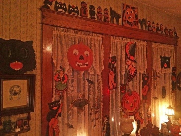 halloween decorations are hanging on the wall in this living room with pumpkins and cats