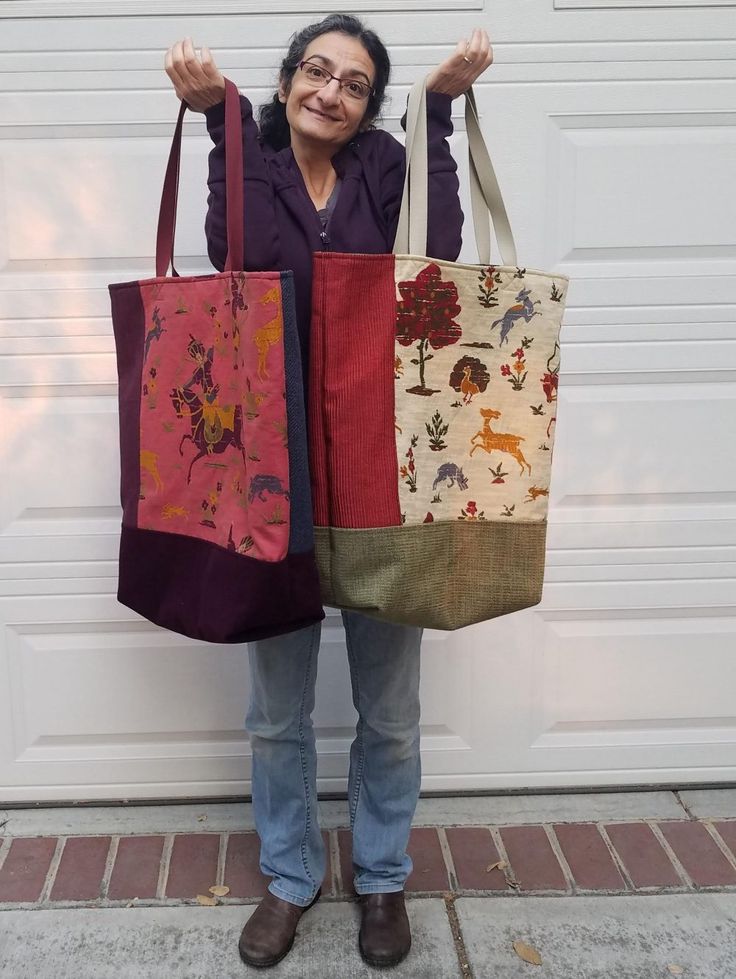 a woman holding two bags in front of a garage door