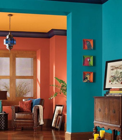 a living room with blue walls and wood flooring in the center is painted bright orange