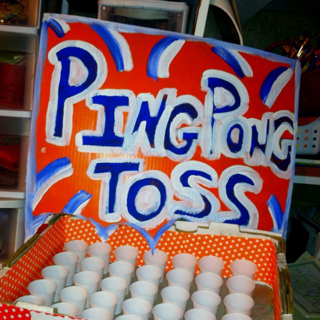 a box filled with lots of white cups next to a sign that says ping pong toss